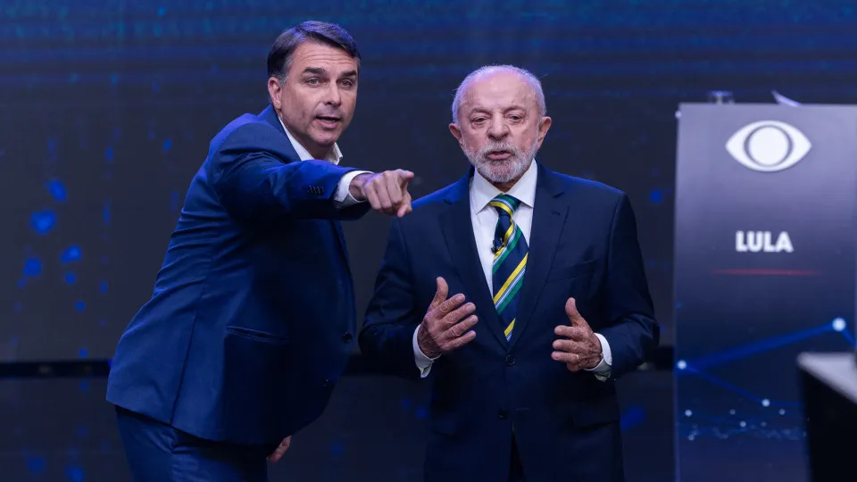 No debate, Flávio adota estratégia de se posicionar e fazer negações ao fundo de falas de Lula, que se irrita